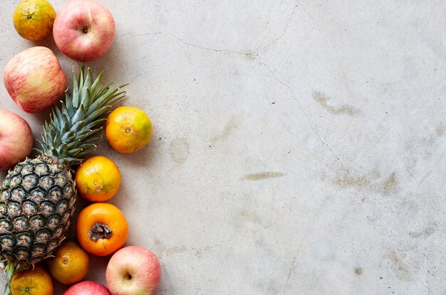 Cornice di frutta fresca su un cemento grigio