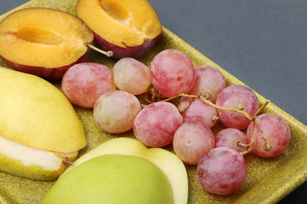 Свежие фрукты виноградная слива яблоко груша в тарелке