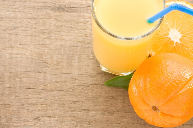 Fresh fruits orange juice in glass on wood board background