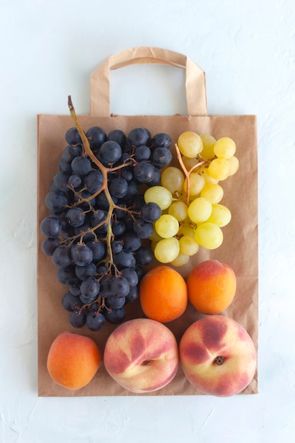 종이 봉지에 있는 신선한 과일, 건강 식품 및 폐기물 제로의 개념, 흰색 배경, 복사 공간, 위쪽 전망