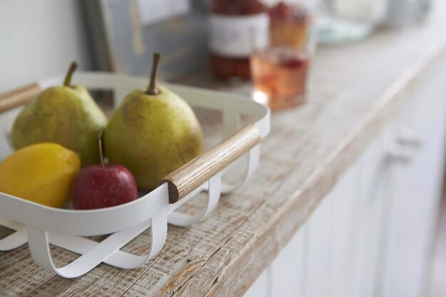 Fresh fruits in plastic rack on the shelf in kitchen interior