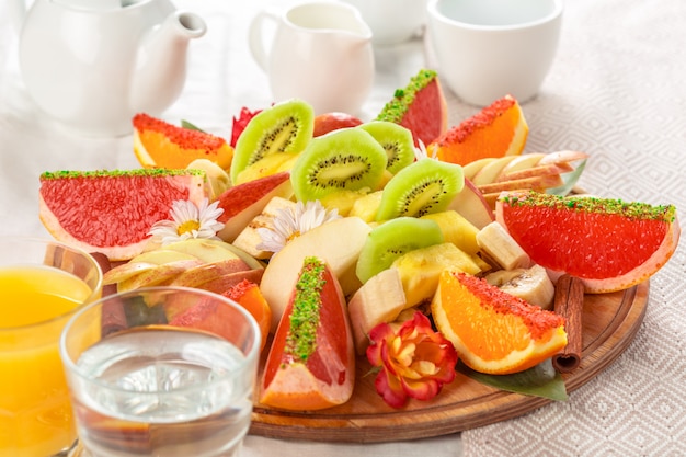 Fresh fruits in plate on wooden table