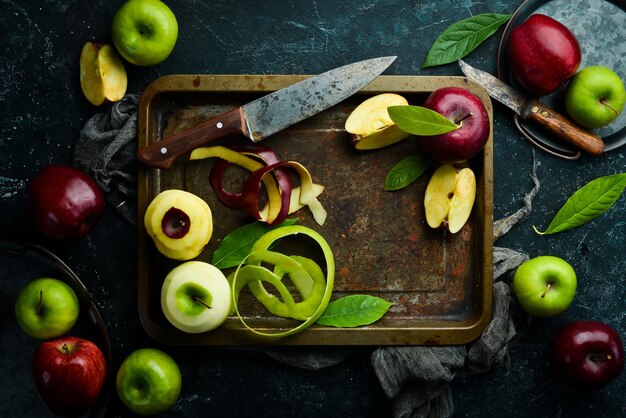 신선한 과일 테이블에 얇게 썬 즙이 많은 빨강 및 녹색 사과 세트 검은 돌 배경의 소박한 스타일