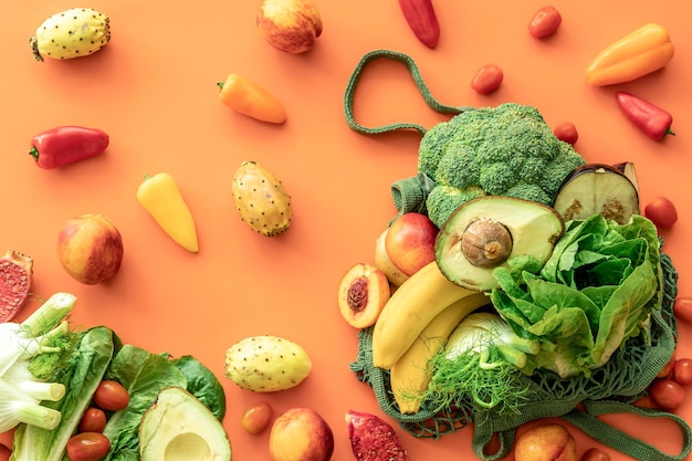 Fresh fruits and vegetables on a colored background flat lay