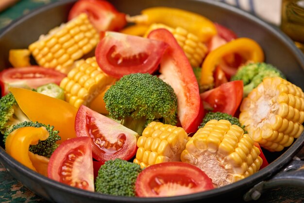 Fresh fruits and vegetables on a frying pan on an old wood background