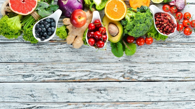 Свежие фрукты и овощи на белом деревянном фоне Вид сверху Свободное место для текста