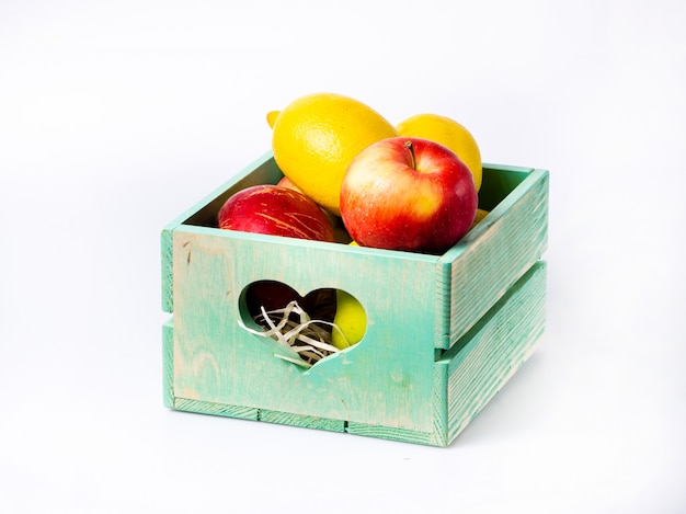 Frutta fresca in scatola di legno isolata su bianco