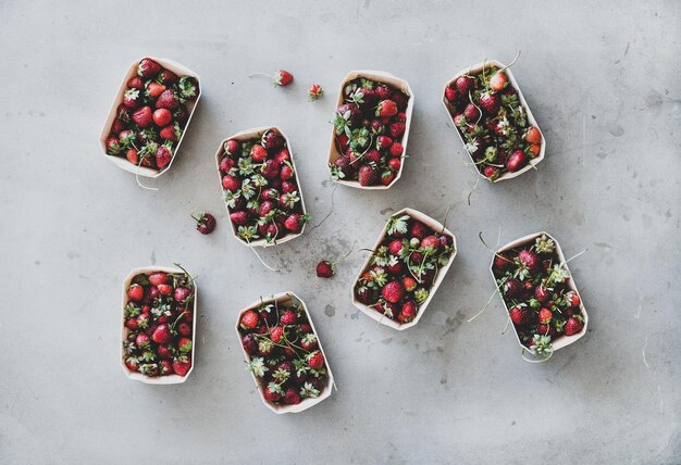 Fresh garden strawberries in ecofriendly plasticfree boxes over grey background