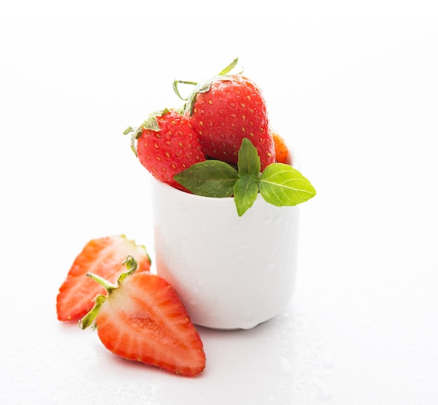 Fresh garden strawberries in a white glass on white