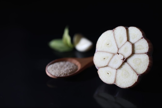 Fresh garlic clove on black background. Garlic is rich in vitamins, useful spring, good spices. Garlic sliced on a dark background. Raw sliced garlic.