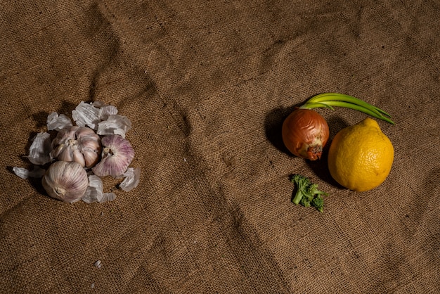 Fresh garlic and other natural cold remedies on sackcloth background