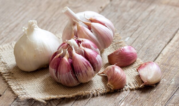 Photo fresh garlic on wooden background close up