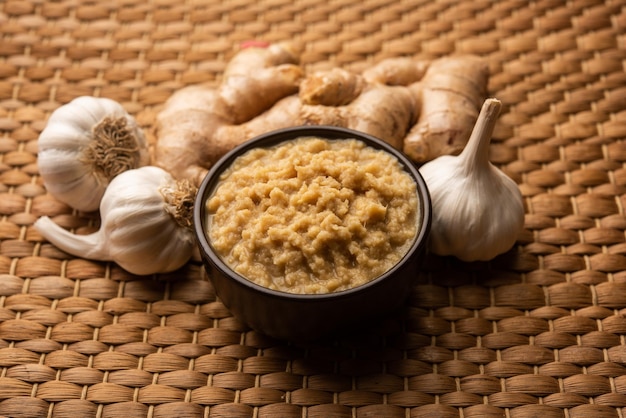 Fresh Ginger and Garlic paste or Adrak Lahsun puree in a ceramic bowl. Selective focus