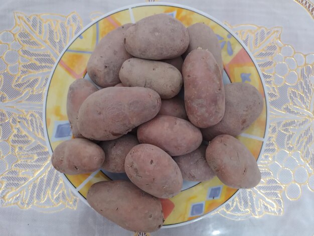 Photo fresh ginger root in a white pot at table