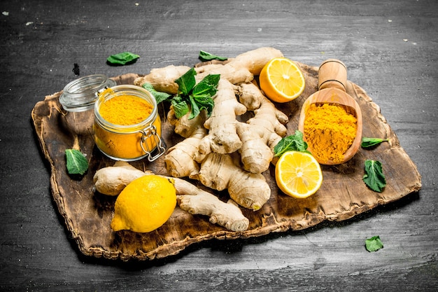 Photo fresh ginger with lemons and mint. on the black chalkboard.