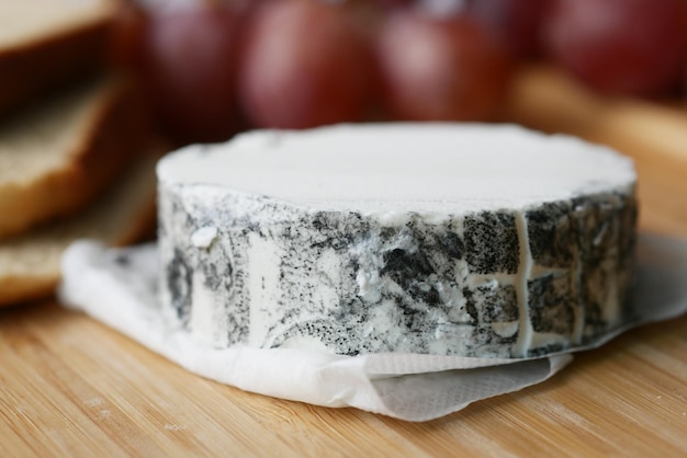 Fresh goat cheese and grape fruit on wooden background