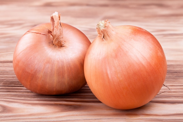 Fresh golden onions on a wooden table