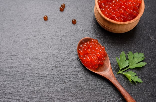 Fresh grainy red chum salmon caviar in a wooden spoon, delicious and healthy food, close up