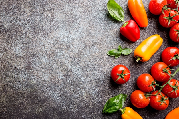 Fresh grape tomatoes with basil and pepper, top view with copy space