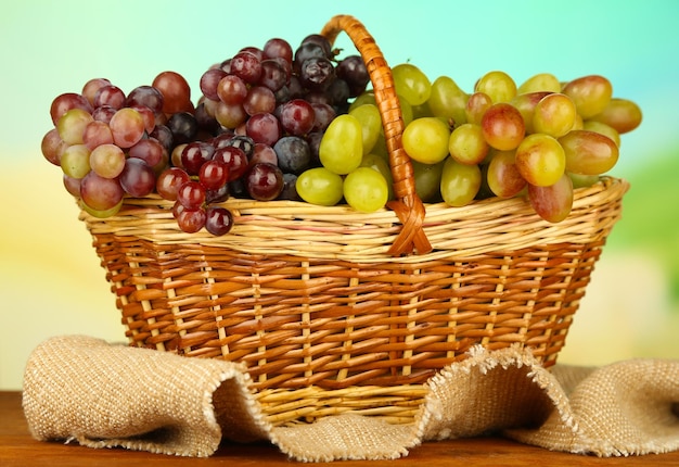 Свежий виноград на плетеной циновке на ярком фоне