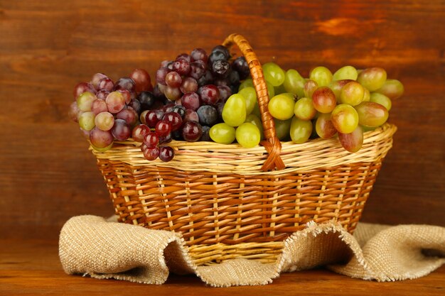 Photo fresh grape on wicker mat on wooden background