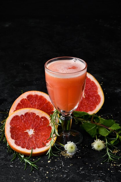 Fresh grapefruit juice in a glass Top view On a black background