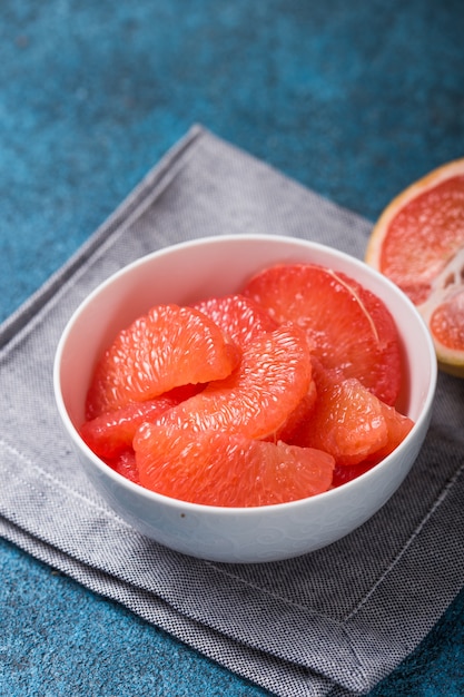 Fresh grapefruit slices in a wooden bowl, healthy snack