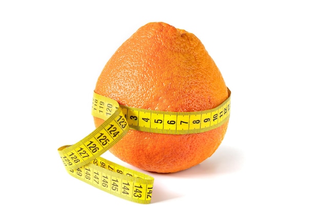 Фото Свежий грейпфрут, обернутый сантиметровой лентой. концепция здорового питания, похудания, диетологии
