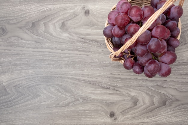 Fresh grapes on basket wood background