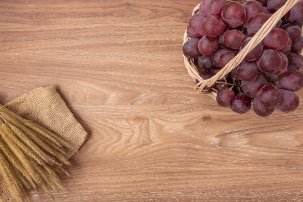 Фото Свежие виноградины на предпосылке древесины корзины. скопируйте место для добавления текста.