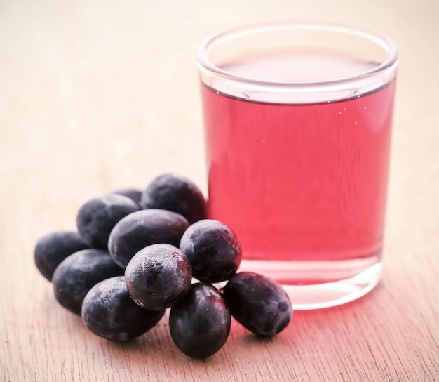 Fresh grapes with juice on wooden surface