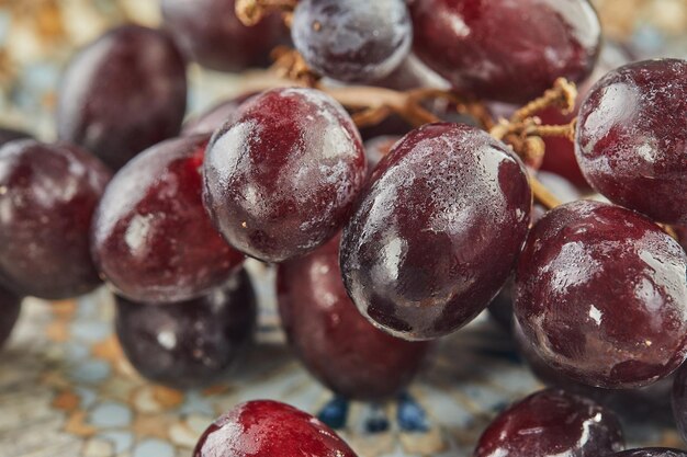 Fresh grapes with water droplets on plate, ready to eat.