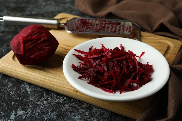 Fresh grated beets on black smokey table
