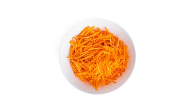 Fresh, grated carrots in a white bowl isolated on white.