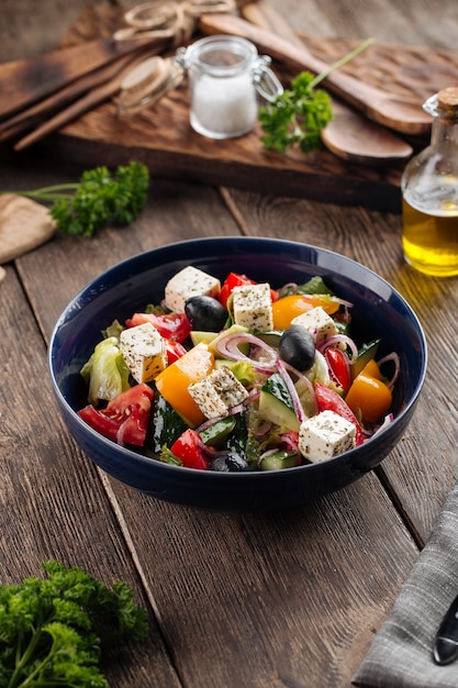 Fresh greek salad in a black bowl