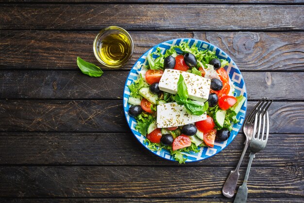 Foto insalata greca fresca di cetriolo, pomodoro, peperone dolce, cipolla rossa, formaggio feta e olive con olio d'oliva