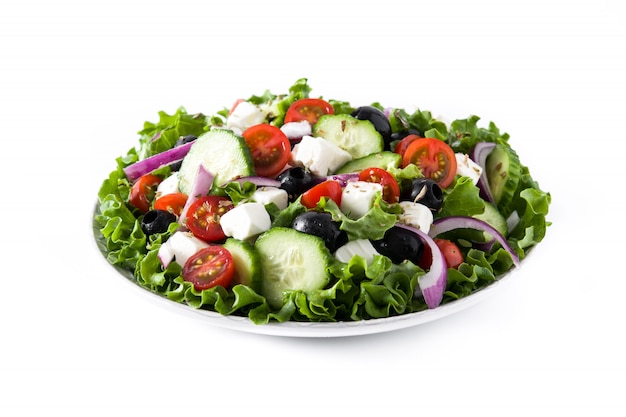Свежий греческий салат в тарелку с черной оливкой, помидор, сыр фета, огурец, изолированные на белом фоне.