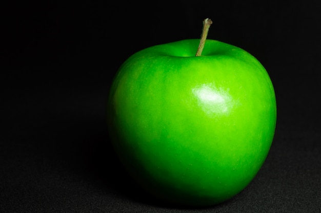 Fresh green apple on black background.