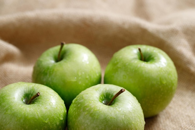 Fresh green apples on sack background