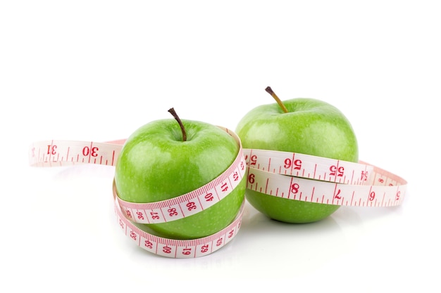 Fresh green apples and white tape measuring isolated on white background.  Healthy fruit concept