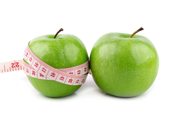 Fresh green apples and white tape measuring isolated on white background. 