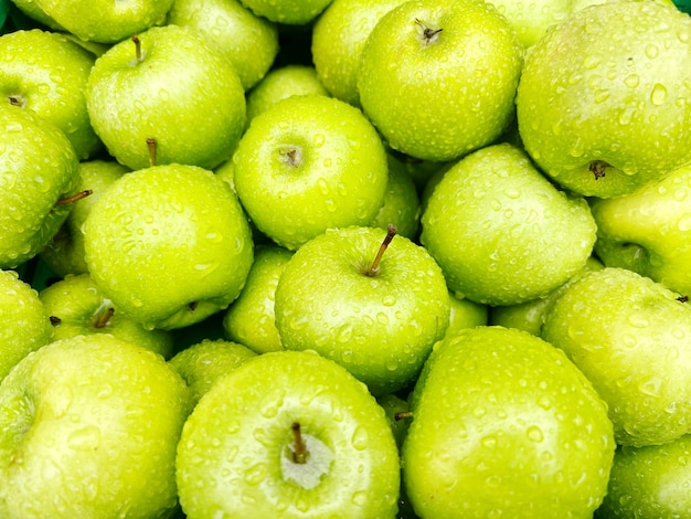 Fresh green apples with water drops fruit background