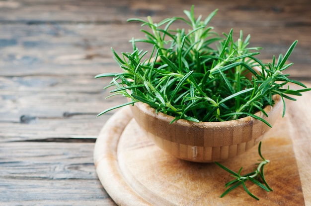 Rosmarini aromatici verdi freschi sulla tavola di legno