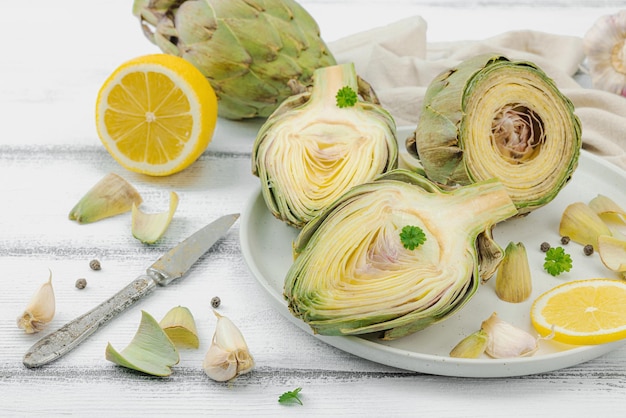 Fresh green artichokes cooking on wooden background Traditional