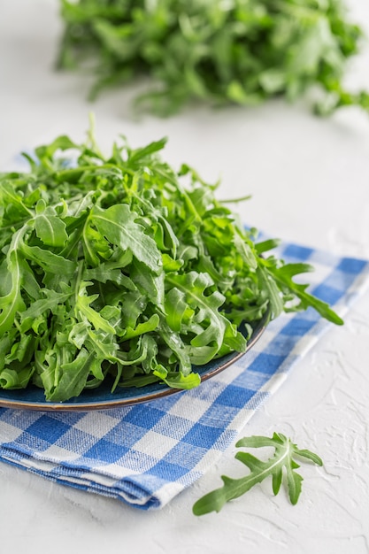 Fresh green arugula in bowl on table. Arugula for salad