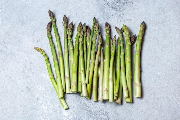 Fresh green asparagus on gray background top view copy space.