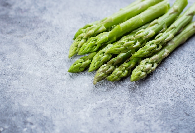 Fresh green asparagus on gray stone table background