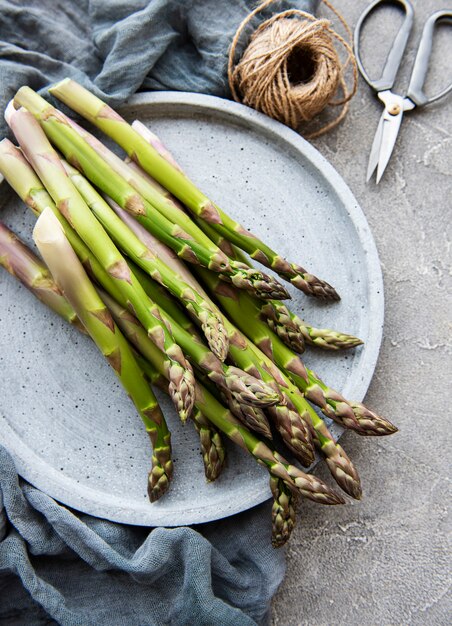 Photo fresh green asparagus  on grey concrete table. flat lay