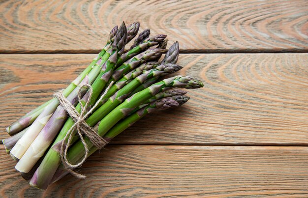 Fresh green asparagus on old wooden table. Flat lay