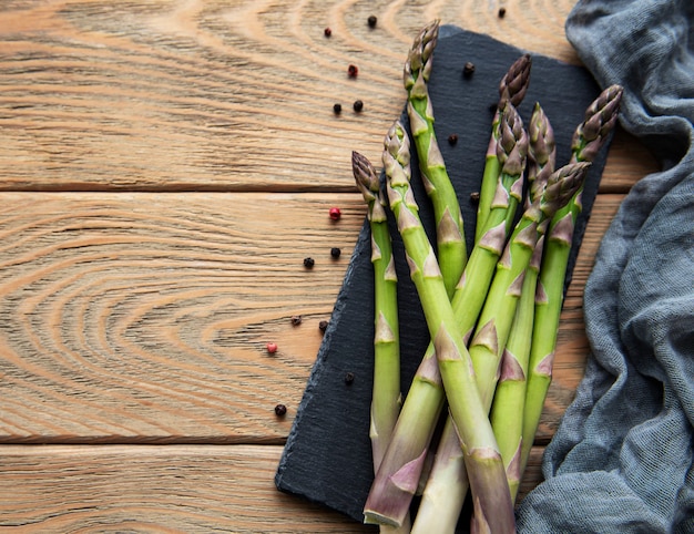 Asparagi verdi freschi sulla vecchia tavola di legno. lay piatto